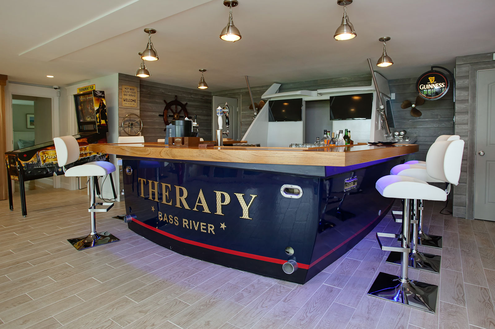 Real-life boat repurposed as a bar for a Cape Cod game room