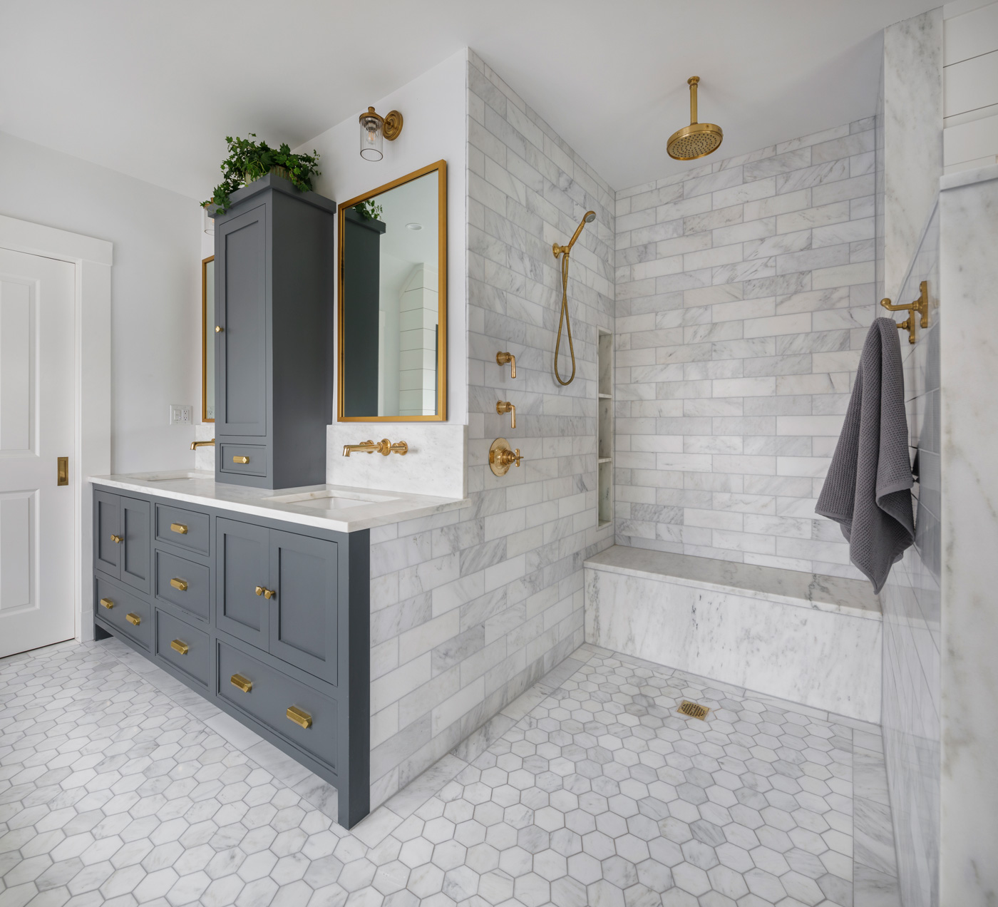 Remodeled master bath with White marble and unlacquered brass fixtures 