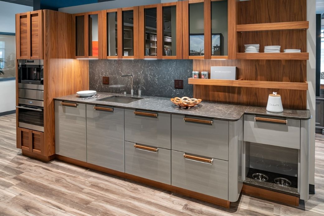 Third view of a sample kitchen by Interiology, featuring warm wooden tones and marble grays with a unique hidden dog bowl.