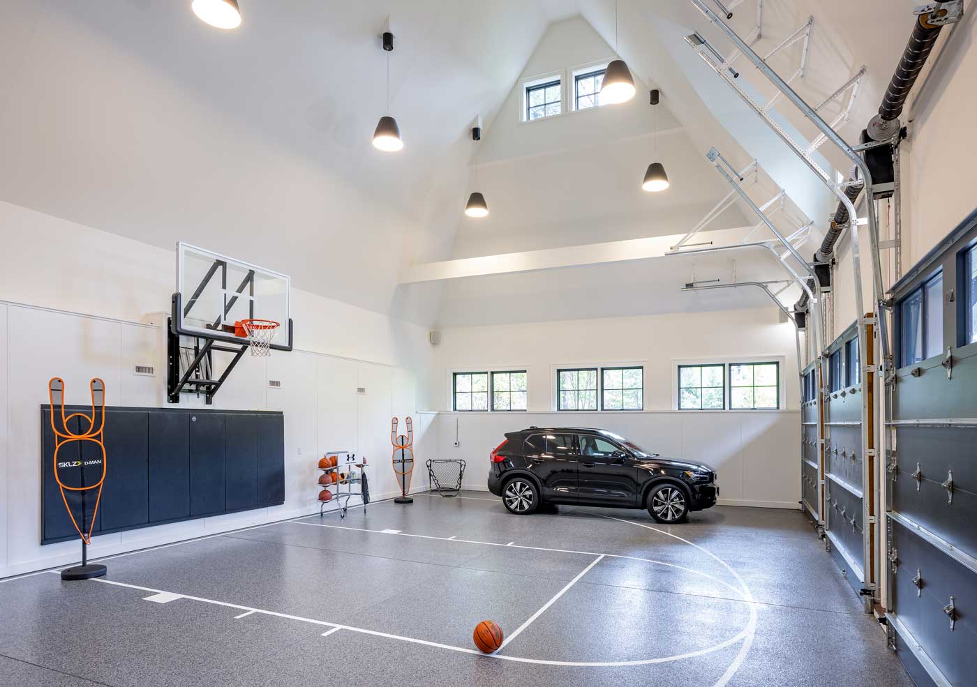 Shingle style home in rural wooded setting - Lynch Construction indoor basketball court and 3 car garage