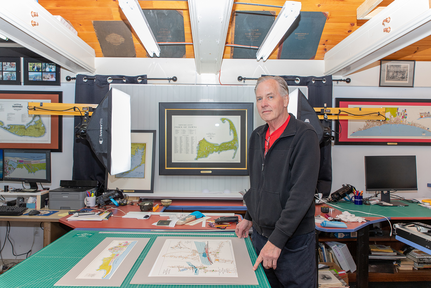 man in his office cutting a frame to fit a map