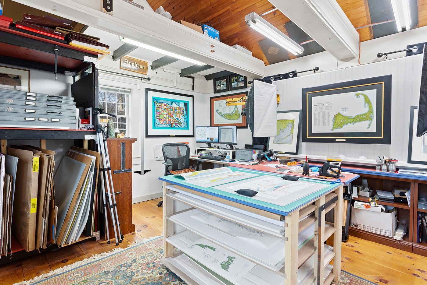 Office with wood ceiling and tray table and maps hanging on the wall