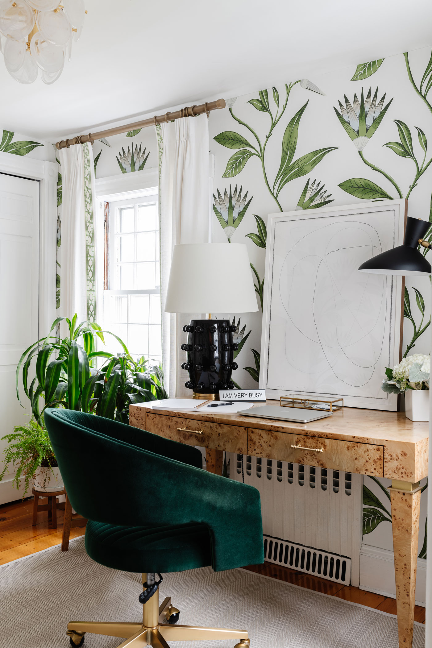 office with small desk green chair and botanical wallpaper