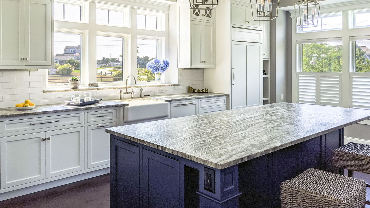 Remodeled white kitchen with blue island and big windows on all sides