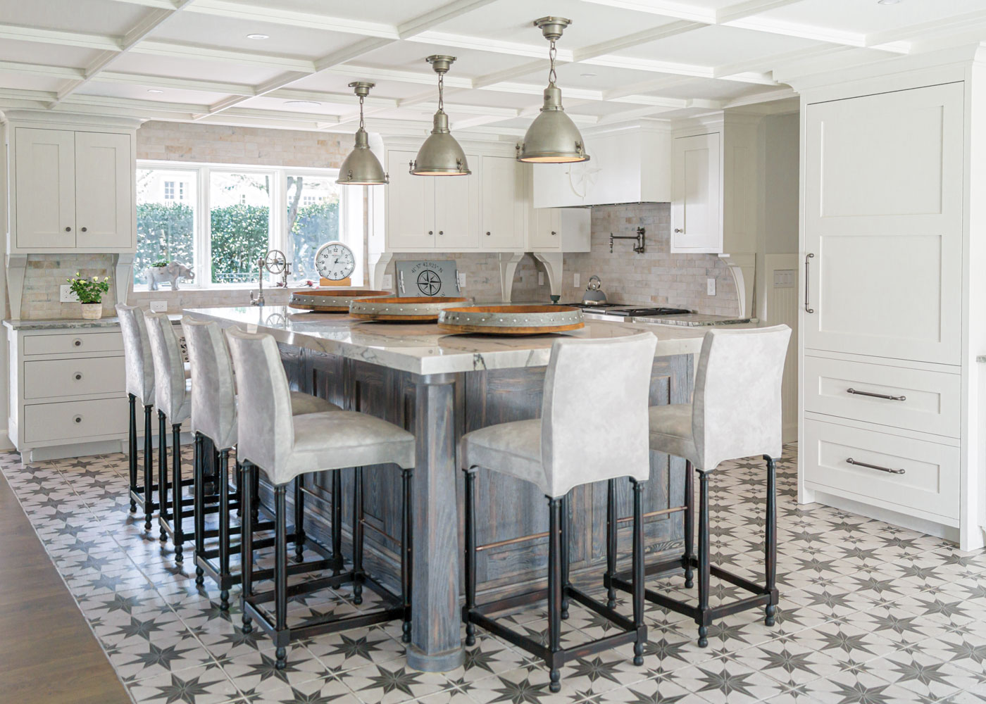 modern kitchen with white cabinets and an oversized island surrounded by stools