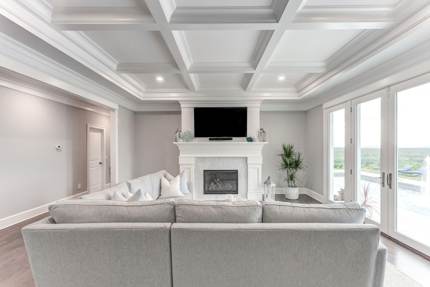 A custom-built mantel and recessed coffered ceiling by Laplante Construction