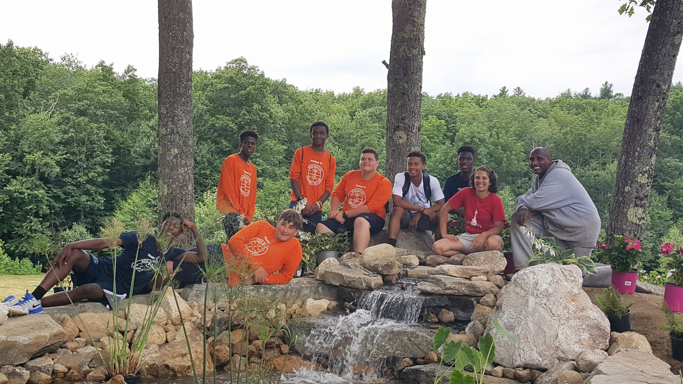 Magma Design Group at Ron Burton Training Village with a group of kids sitting at a waterfall