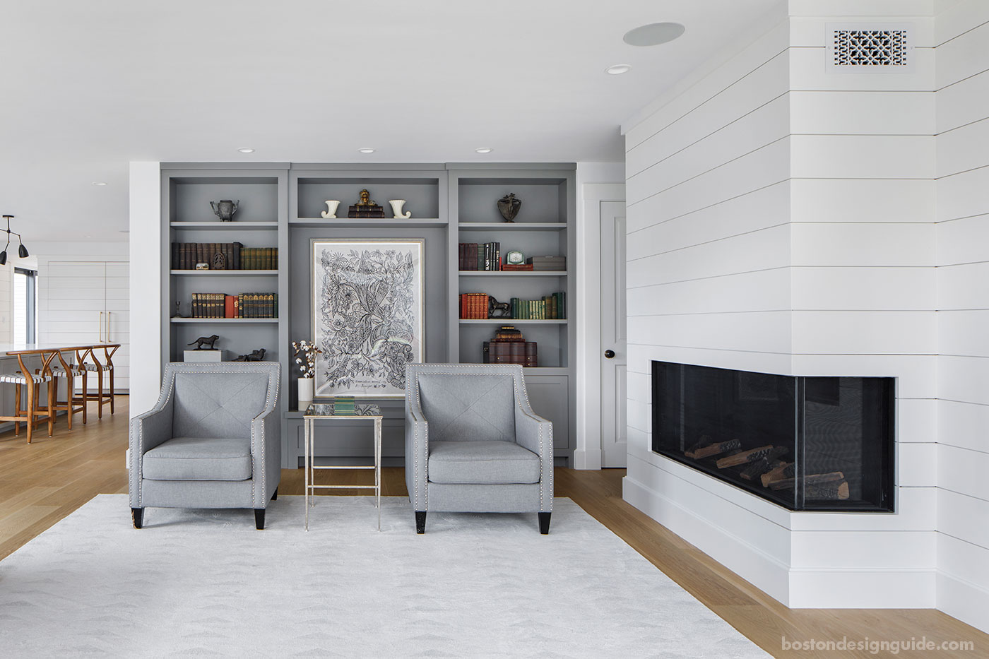 Custom New England living room by custom home builder McCormack Builders with nickel gap wood paneling