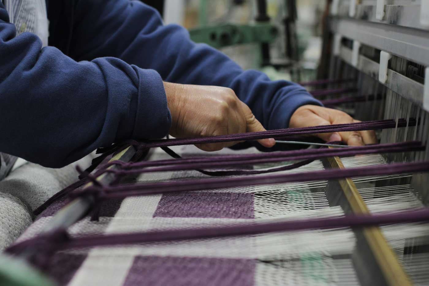 person operating a weaving machine