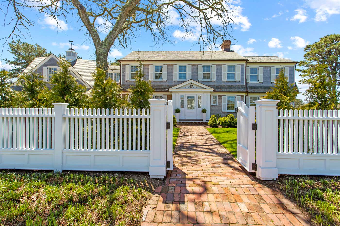 front of redesigned home with white gate surrounding the house