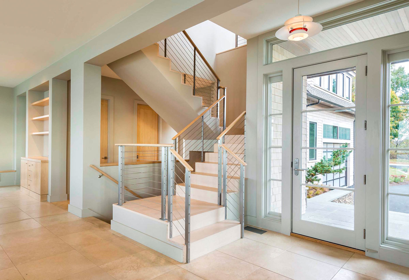 front entry of home with glass doors, tiled floor and stairway