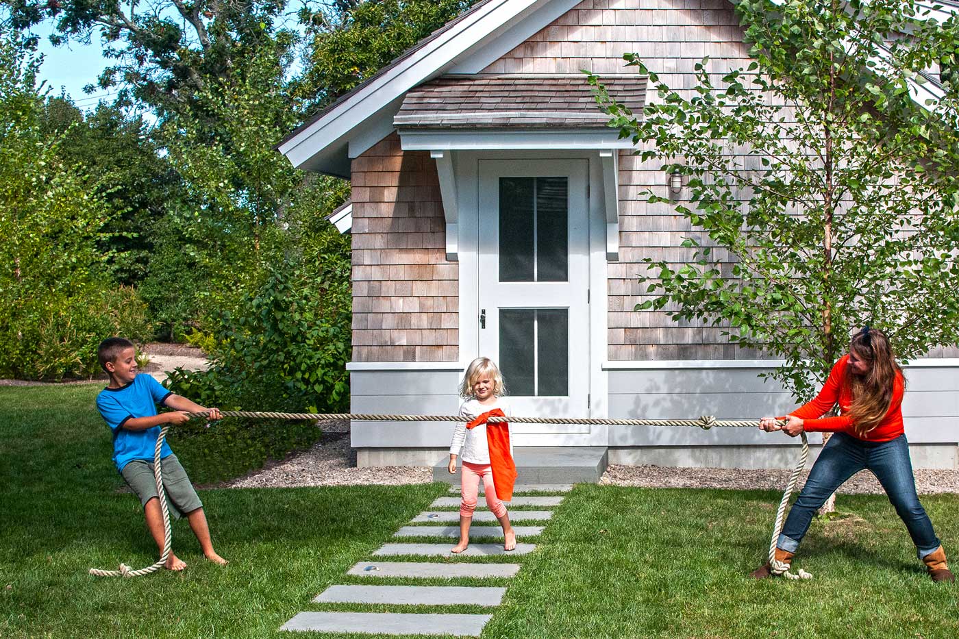 woman playing tug a war with kids