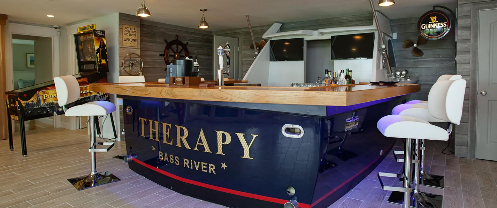 Real-life boat repurposed as a bar for a Cape Cod game room