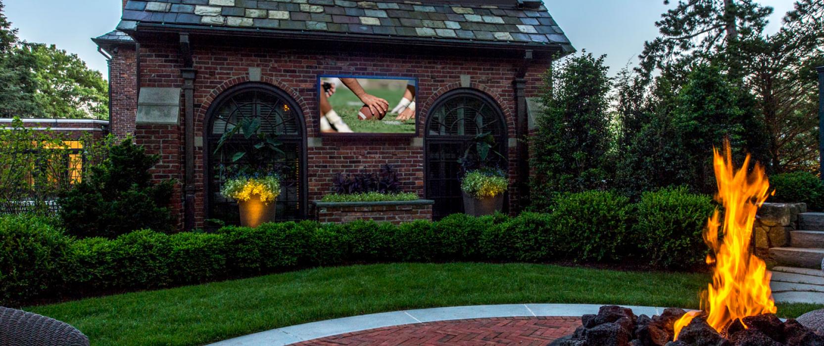 Landscape design featuring an outdoor TV, with home integration by Creative Systems