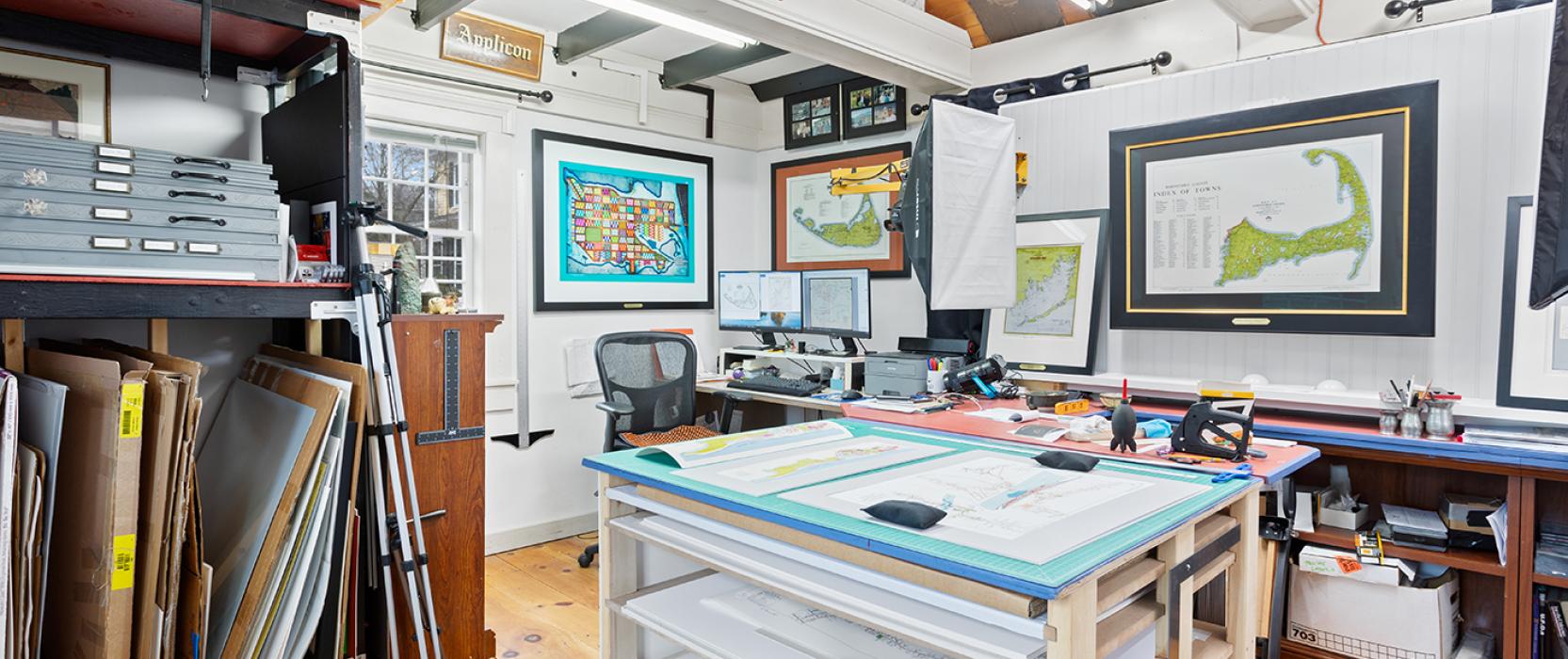Office with wood ceiling and tray table and maps hanging on the wall