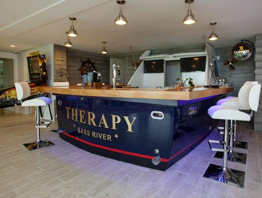 Real-life boat repurposed as a bar for a Cape Cod game room