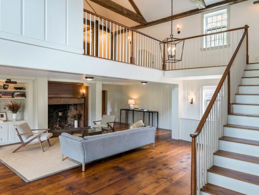 custom living area with vaulted ceilings and a stairway that leads to open second floor