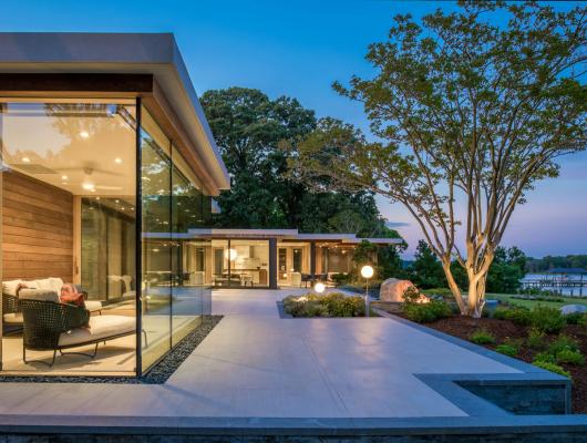 Custom home with floor to ceiling windows overlooking the water