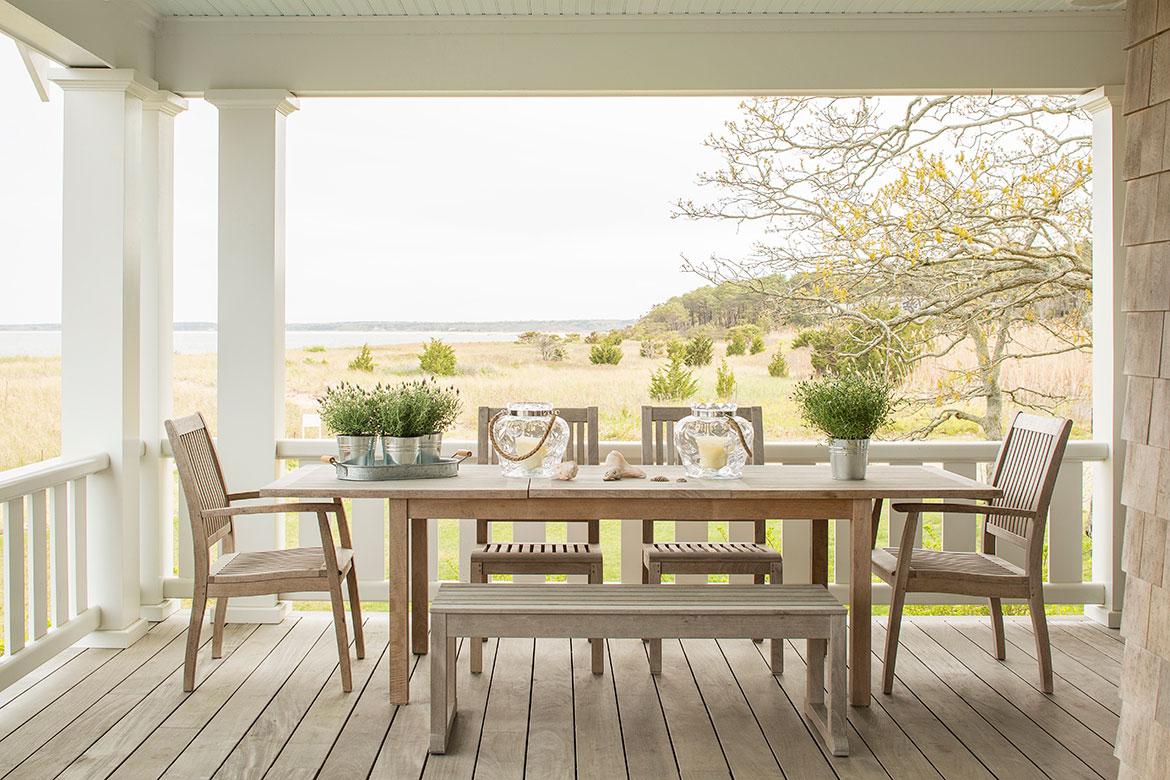 Teak table and chairs on a deck overlooking the ocean and marsh