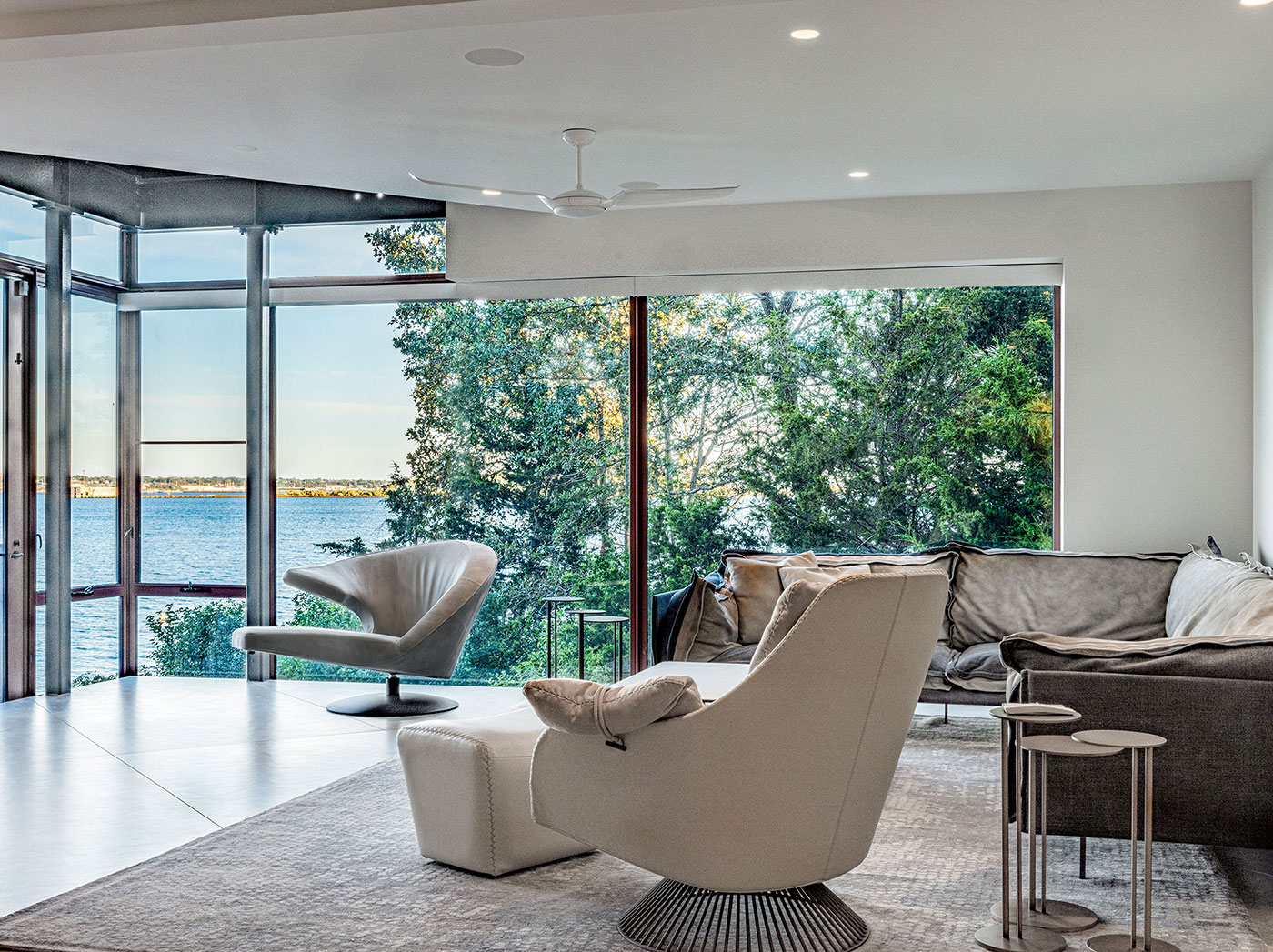 Modern living room with panoramic coastal views by Divine Design Center