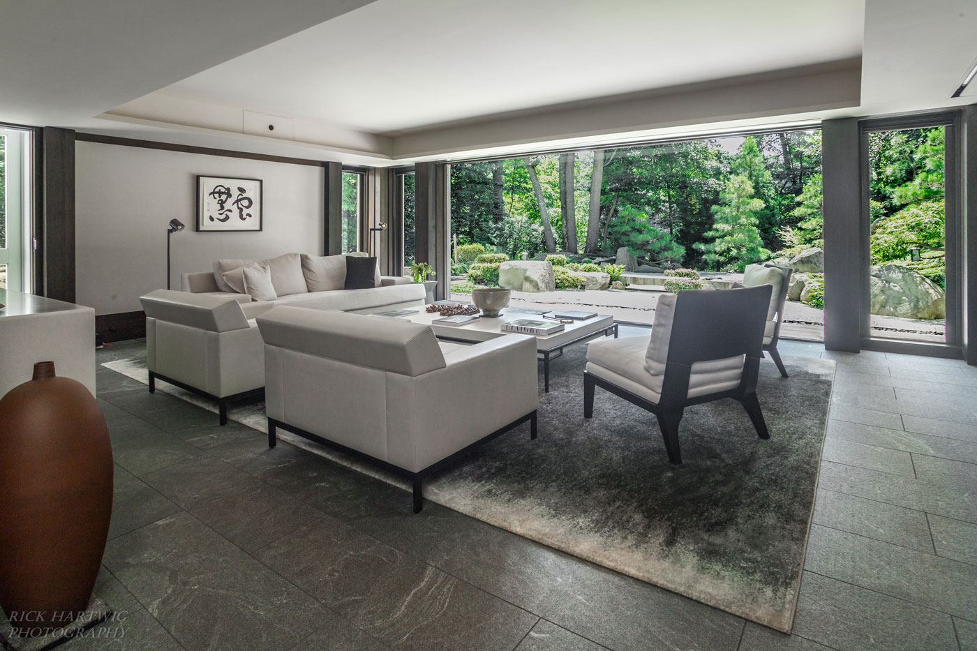 Serene living area with floor to ceiling windows looking out into nature