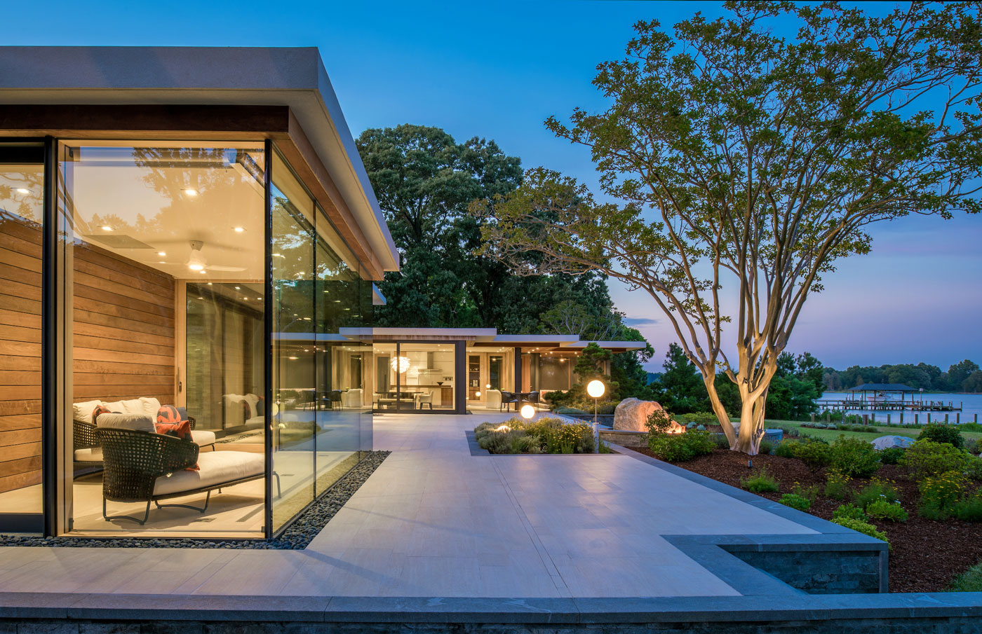 Custom home with floor to ceiling windows overlooking the water