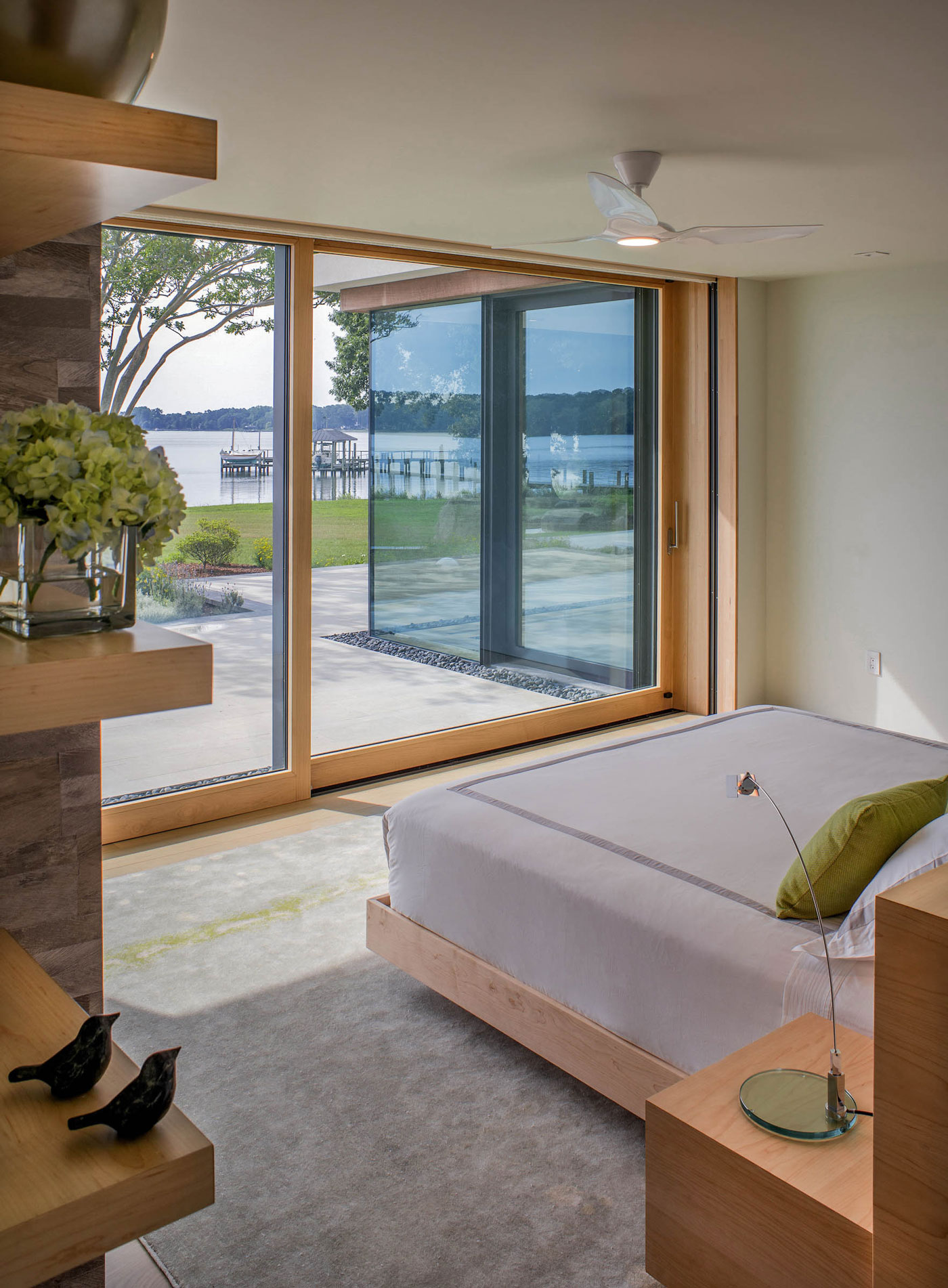 Bedroom with full length windows overlooking the water